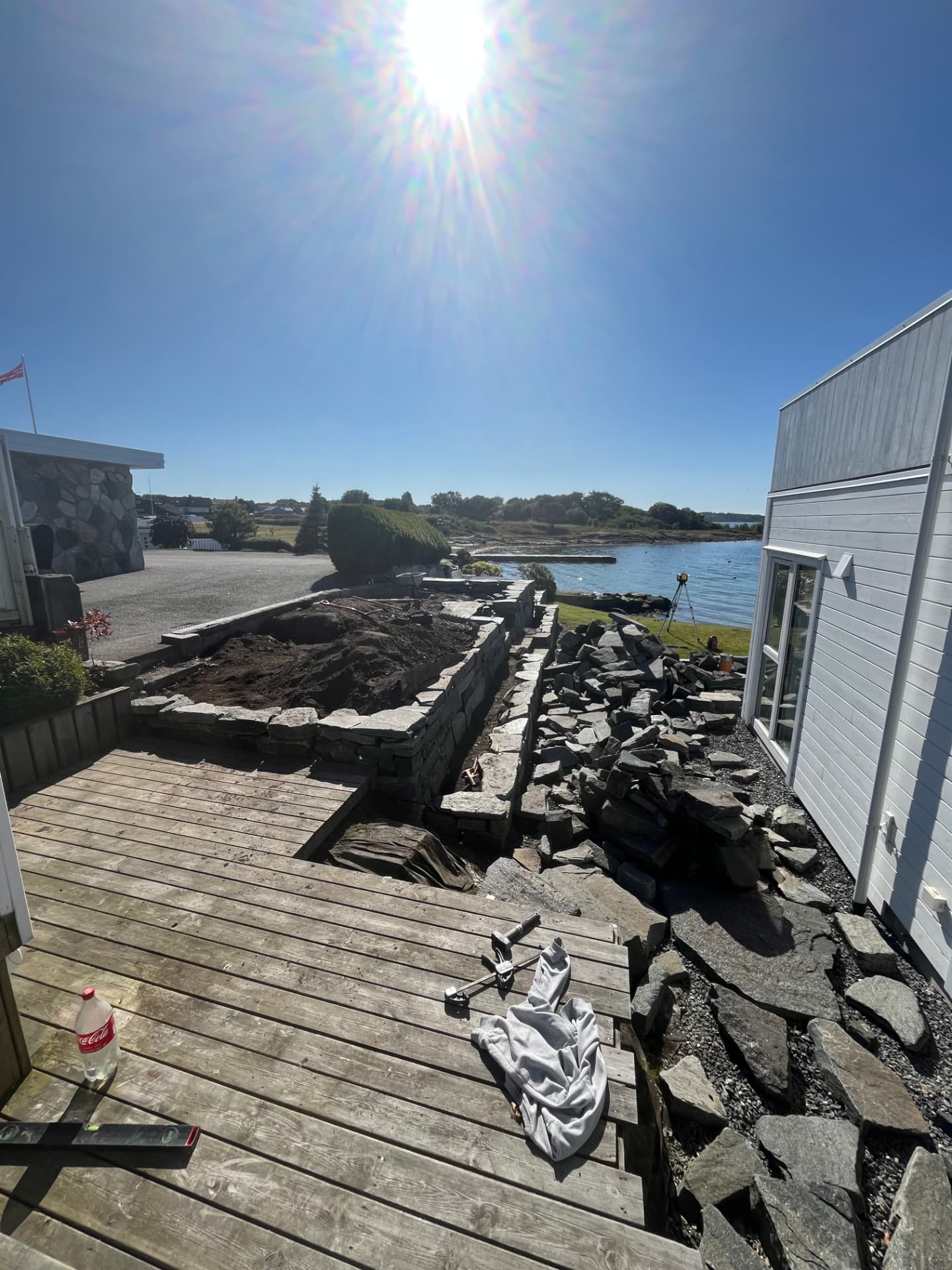 Natursteinsmuren under oppbygging med drenerende masser bak muren