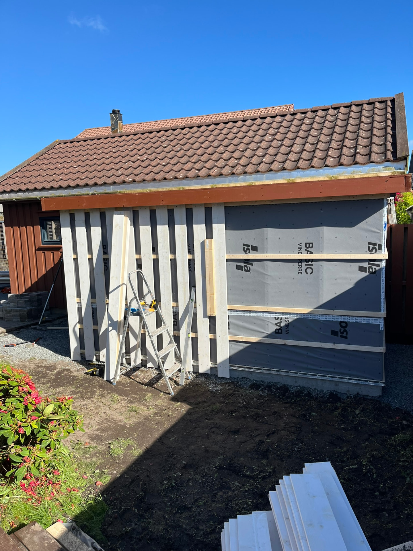 Uteboden under bygging med reisverk og vindsperre inntil huset