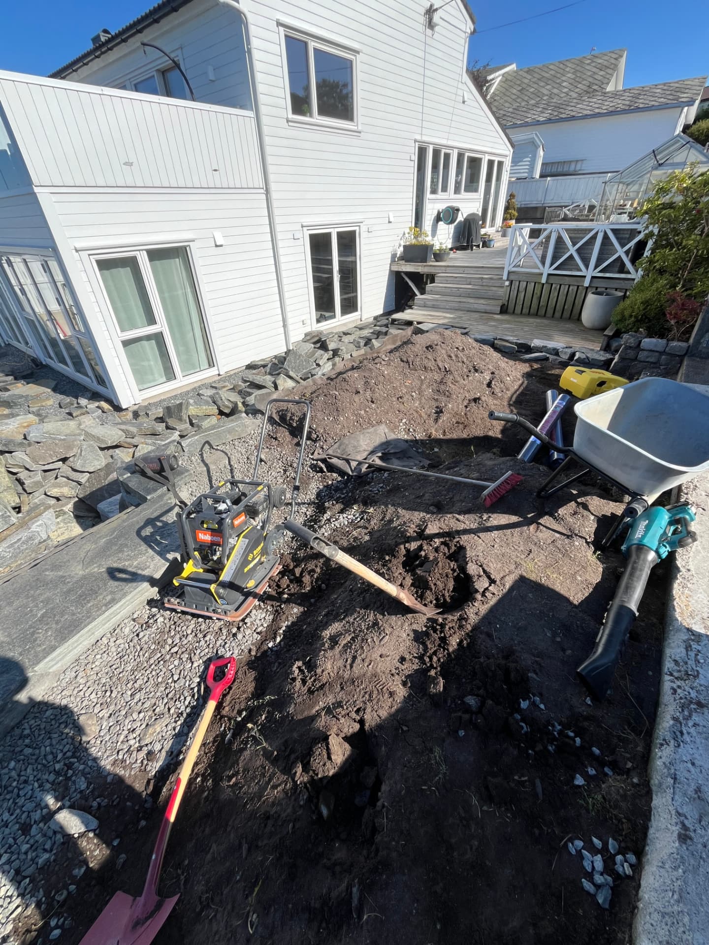 Området bak muren graves ut og klargjøres med masser før plen