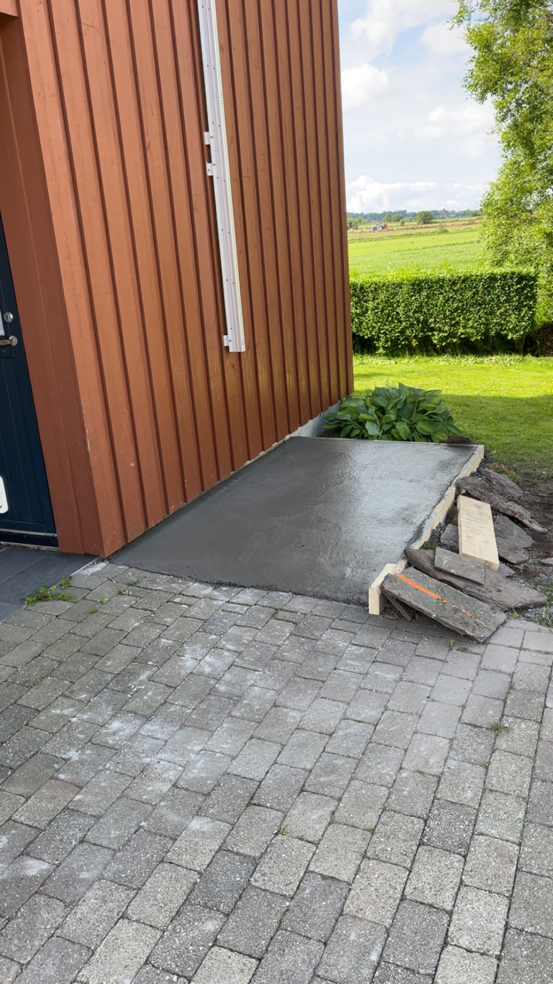 Nystøpt fundament til søppeldunkene langs husveggen