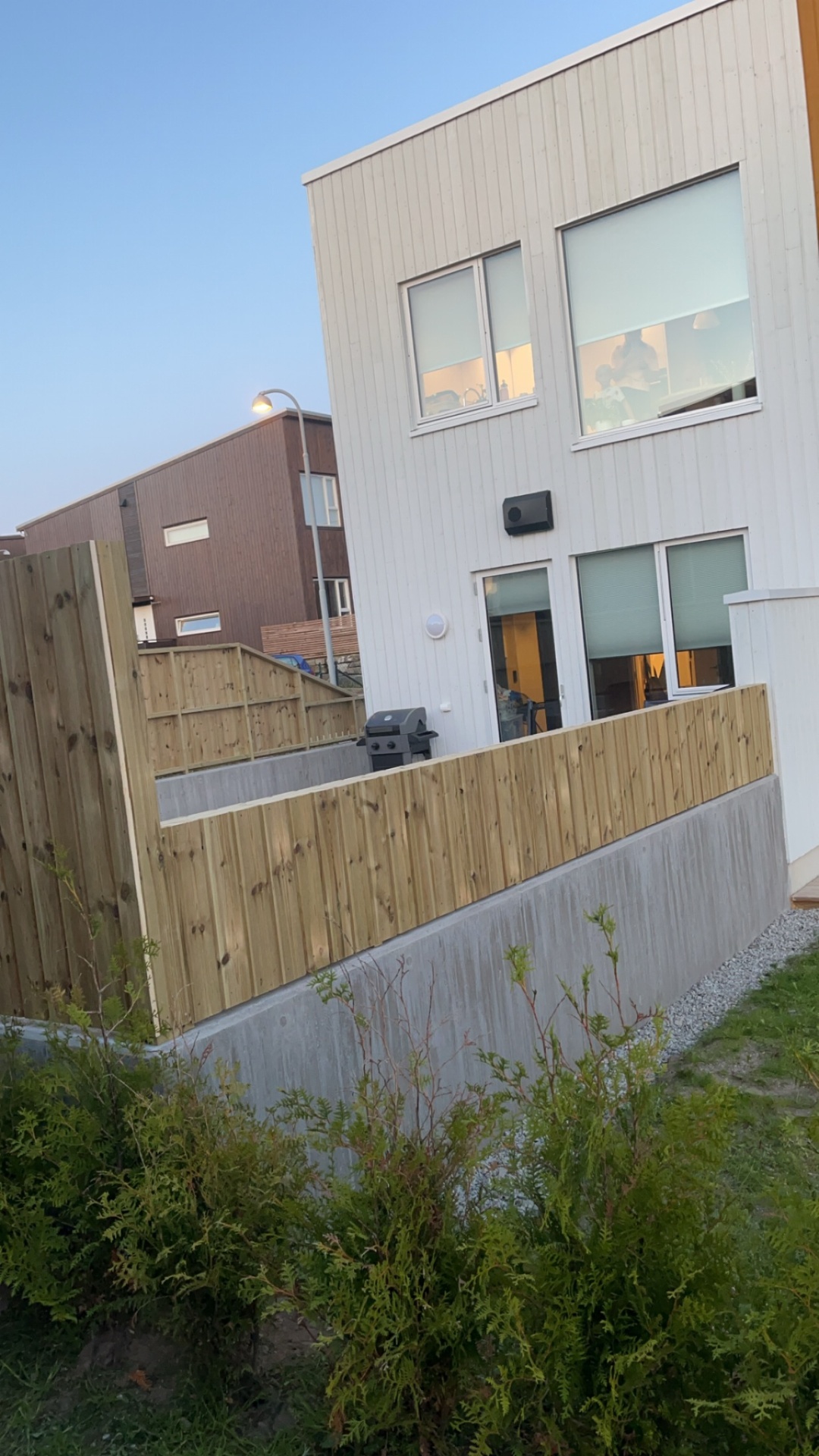 Ferdig uteplass med skjermvegg og grillsone bak bolig