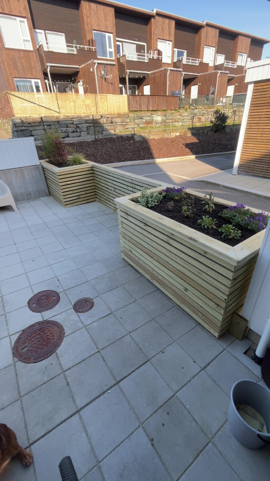 Uteplass med plantekasser, beplantning og helhetlig oppgradering i gårdsrom