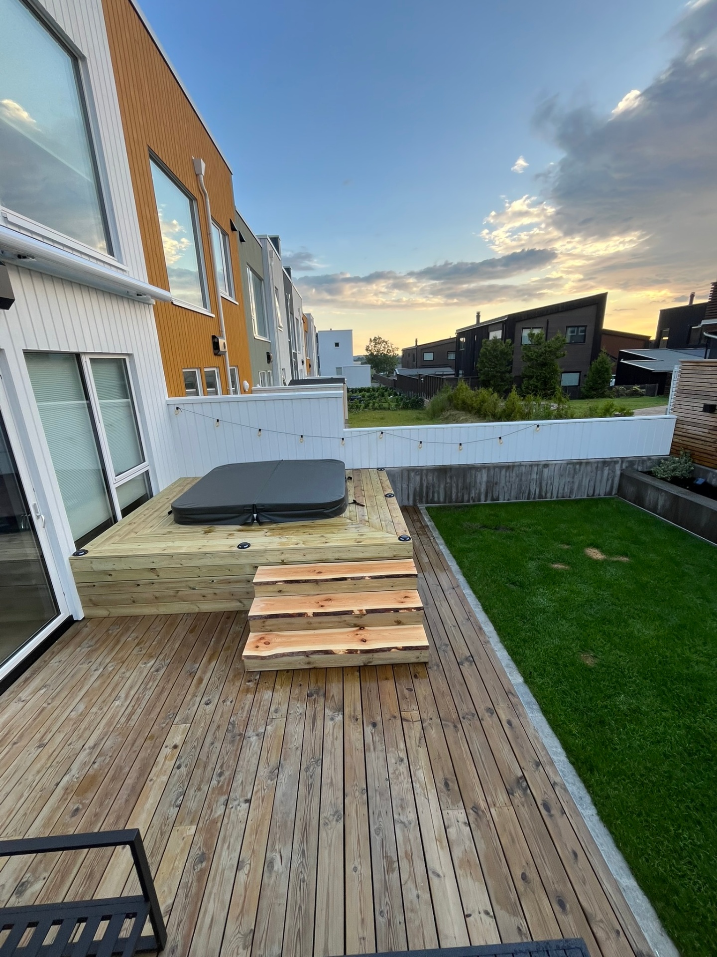 Oversiktsbilde av ferdig jacuzzi-platting og terrasse ved skumring